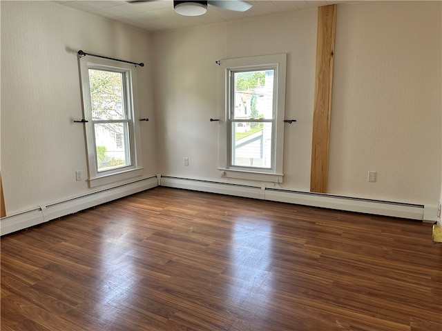 unfurnished room with a baseboard heating unit, dark hardwood / wood-style flooring, a wealth of natural light, and ceiling fan