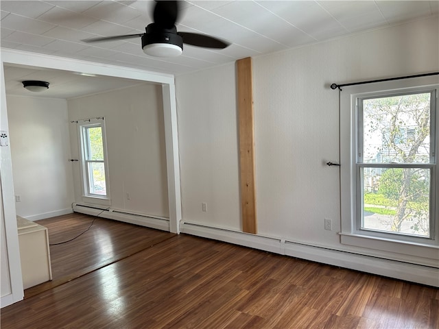 spare room with hardwood / wood-style flooring, a baseboard heating unit, a wealth of natural light, and ceiling fan