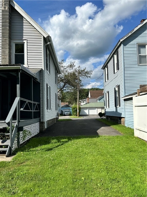 view of yard featuring a garage and an outbuilding