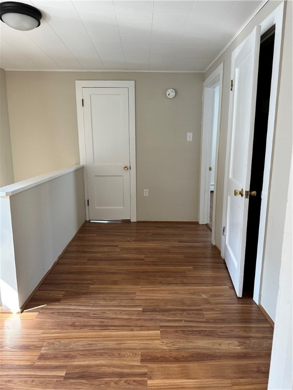 corridor with hardwood / wood-style flooring