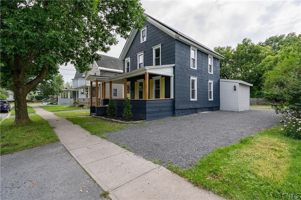 view of property exterior with a porch and a lawn