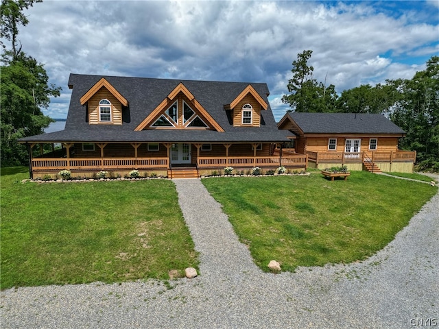 cabin with a front lawn and covered porch