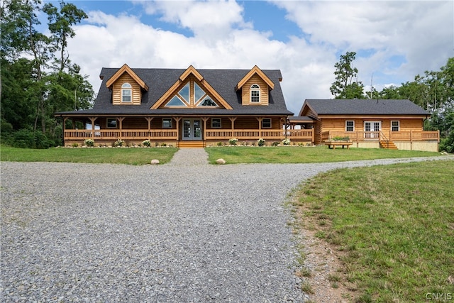 log home with a front lawn and covered porch