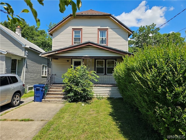 view of front facade featuring covered porch and a front lawn