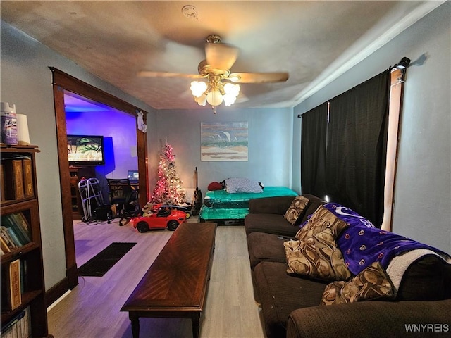 living area with a ceiling fan and wood finished floors