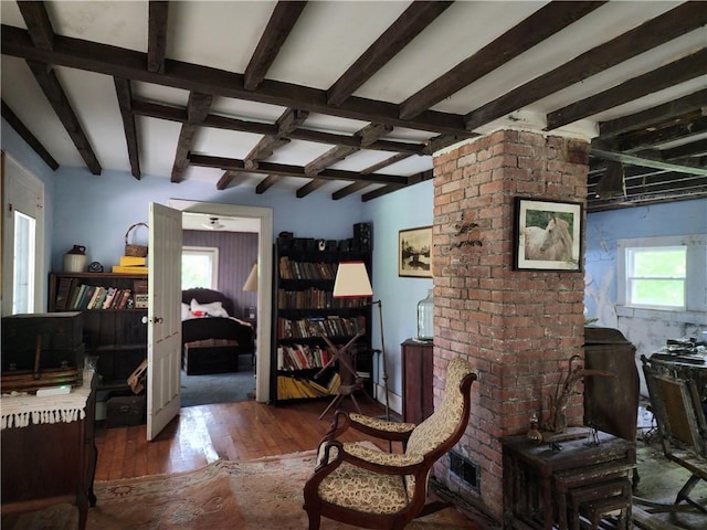 sitting room featuring dark hardwood / wood-style flooring and beam ceiling