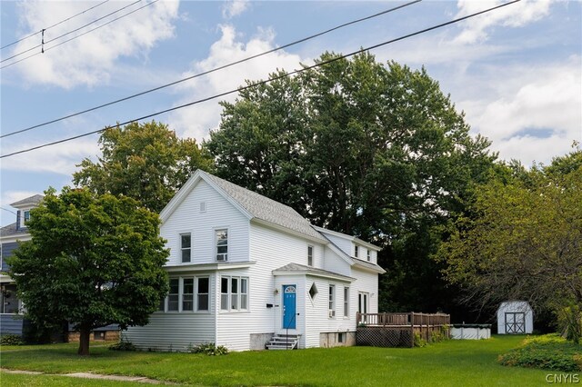 view of front facade featuring a storage shed and a front yard