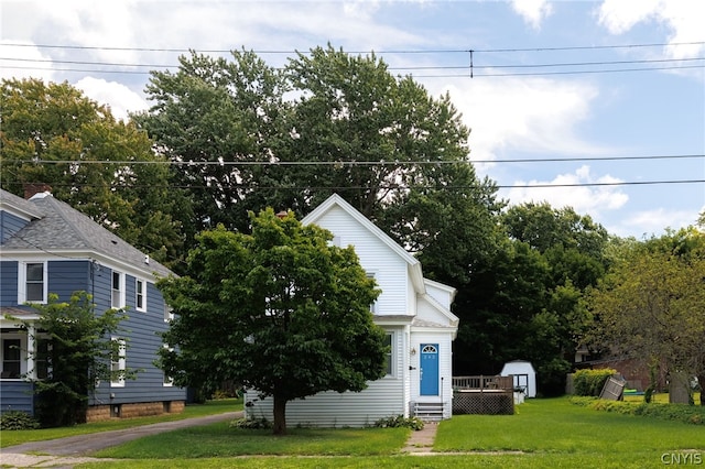 view of front of property with a shed and a front yard