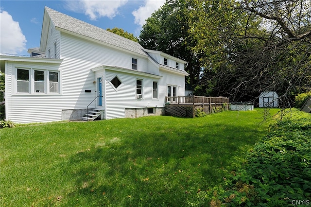 rear view of house with a deck, a storage unit, and a yard