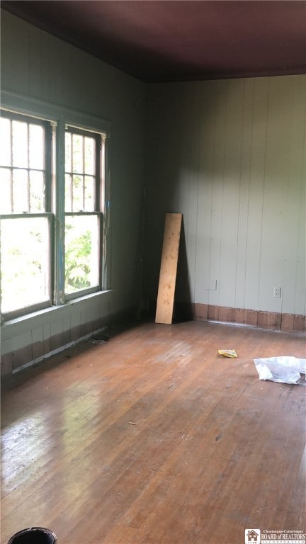 spare room with wood-type flooring and a healthy amount of sunlight