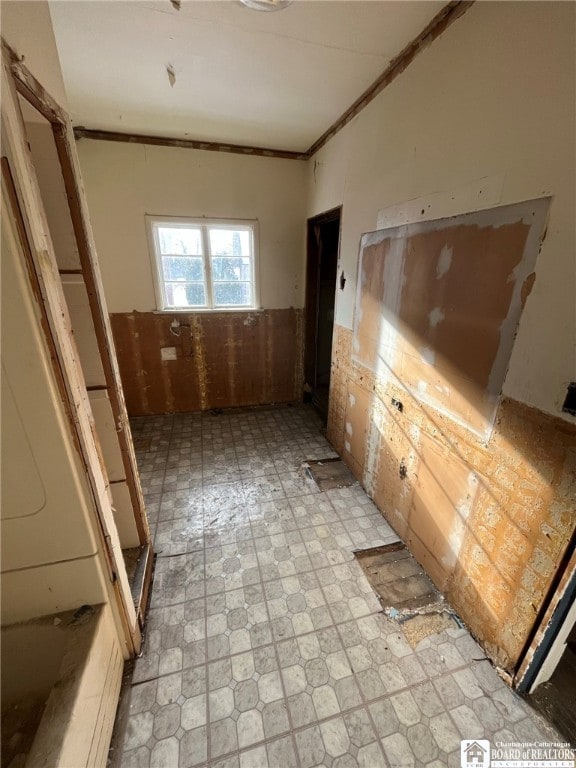 interior space with light tile patterned floors and ornamental molding