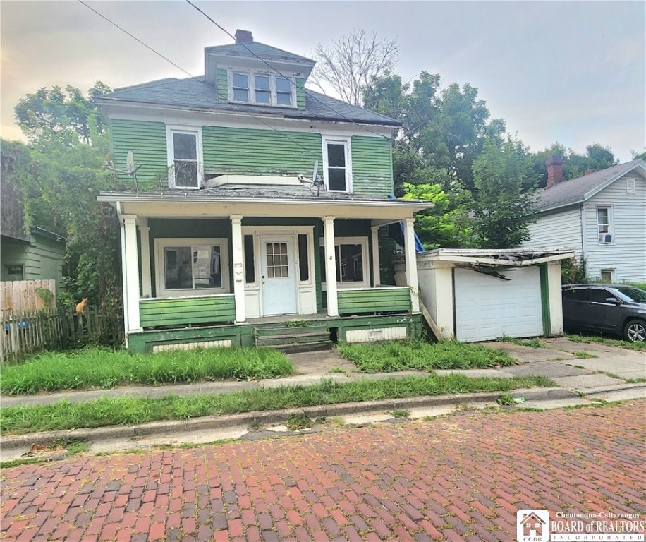 view of front of property with covered porch, an outdoor structure, and a garage