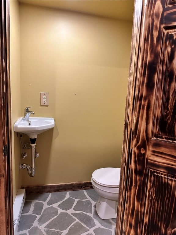 bathroom with toilet and baseboard heating