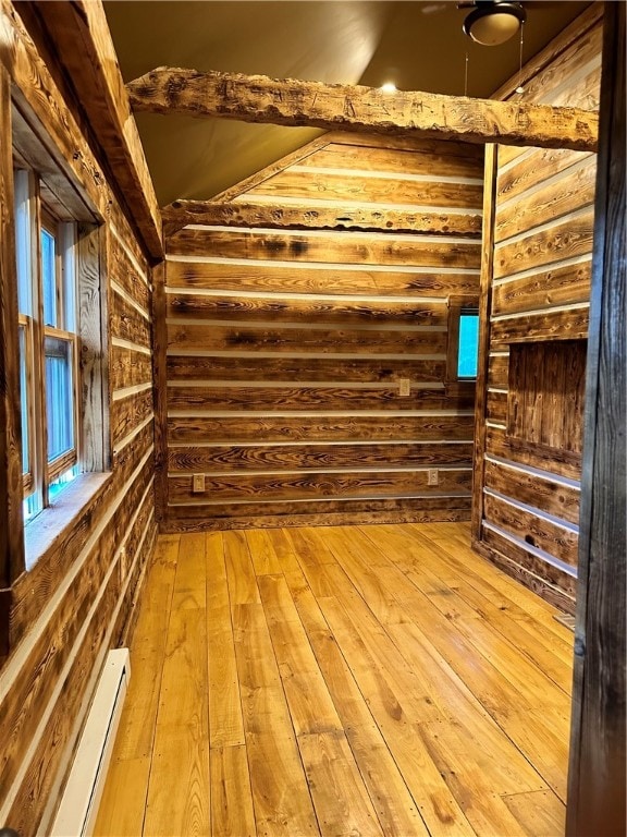 empty room with baseboard heating and light hardwood / wood-style floors