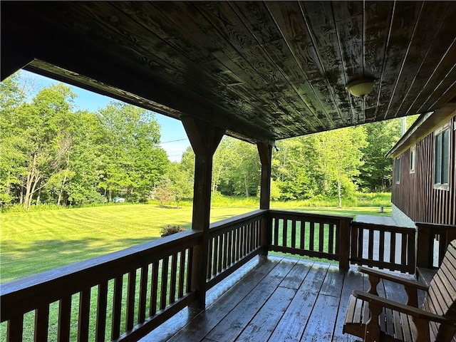 wooden deck featuring a lawn