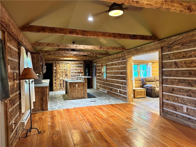 unfurnished living room with light hardwood / wood-style floors, ceiling fan, and vaulted ceiling with beams