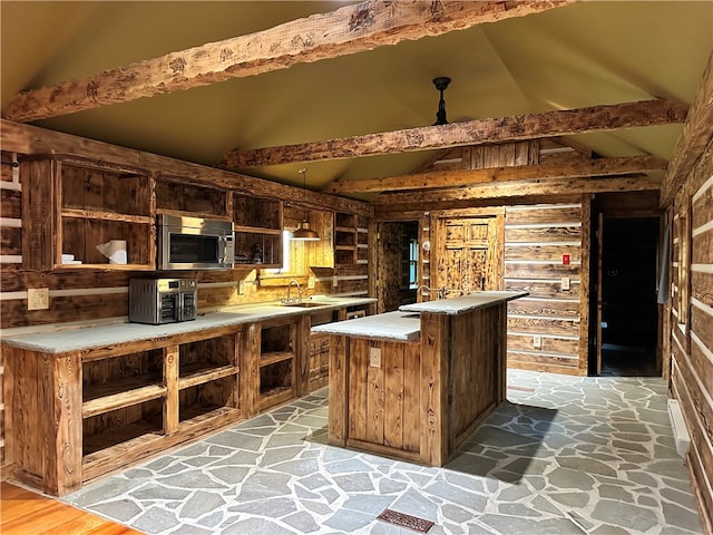 kitchen with decorative light fixtures, hardwood / wood-style flooring, vaulted ceiling with beams, and a kitchen island