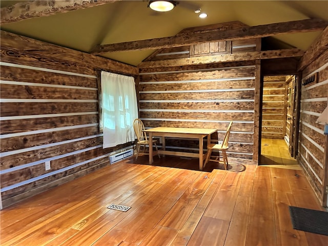 unfurnished dining area featuring wood-type flooring and vaulted ceiling