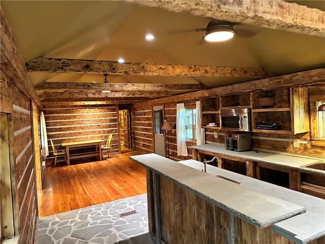 kitchen featuring light hardwood / wood-style floors, sink, dark brown cabinets, and vaulted ceiling with beams