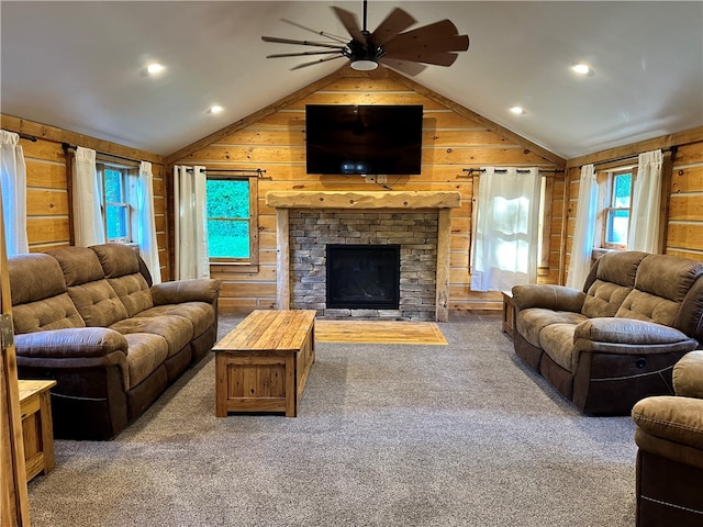 living room with a stone fireplace, carpet, wooden walls, and lofted ceiling