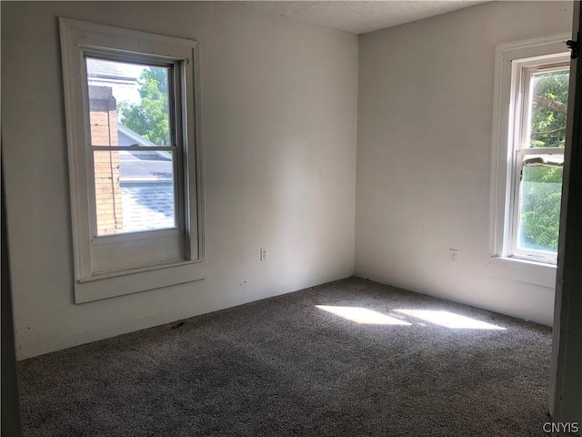 unfurnished room featuring dark colored carpet