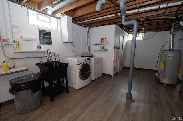 clothes washing area with separate washer and dryer, wood-type flooring, and water heater