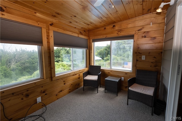 sitting room featuring carpet flooring, a healthy amount of sunlight, wooden walls, and wooden ceiling