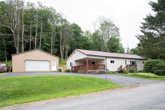 view of front facade with a garage, an outbuilding, a deck, and a front lawn