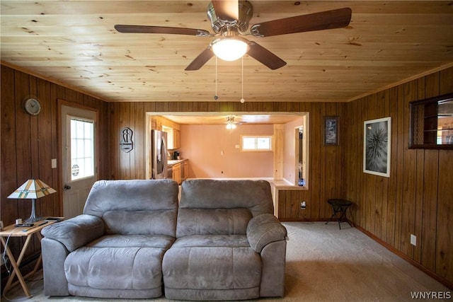 living room with light colored carpet, wood ceiling, and wood walls