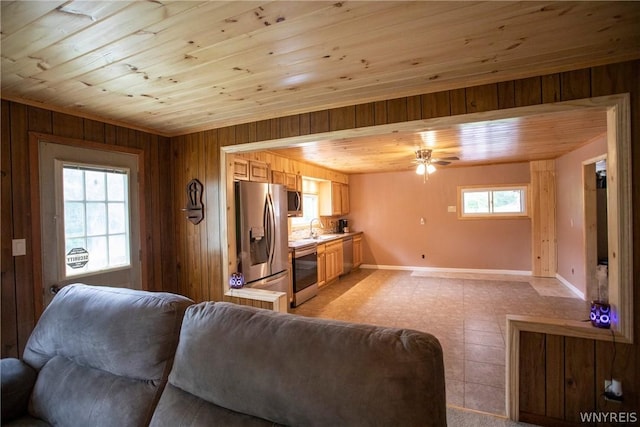 living room featuring sink, wooden walls, wooden ceiling, and ceiling fan