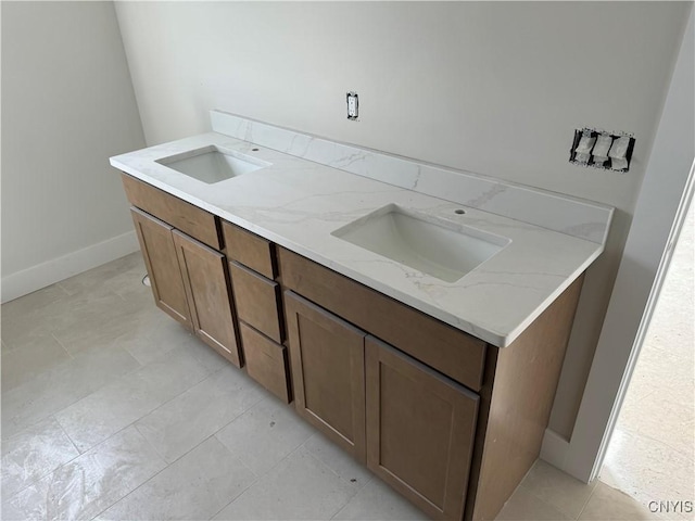 kitchen featuring light stone counters and sink