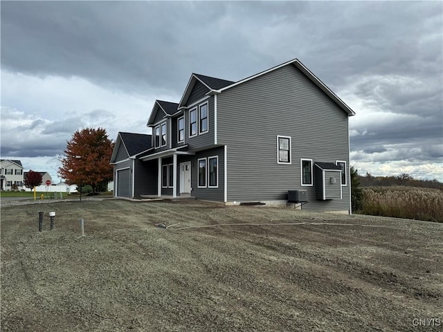 view of side of property with cooling unit and a garage