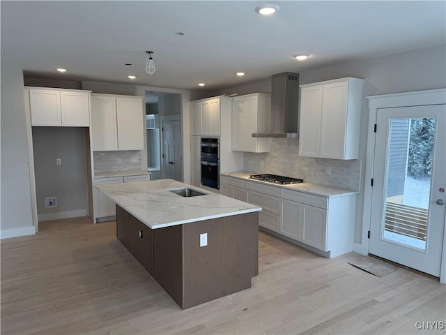 kitchen with a center island, white cabinets, wall chimney range hood, decorative backsplash, and stainless steel appliances