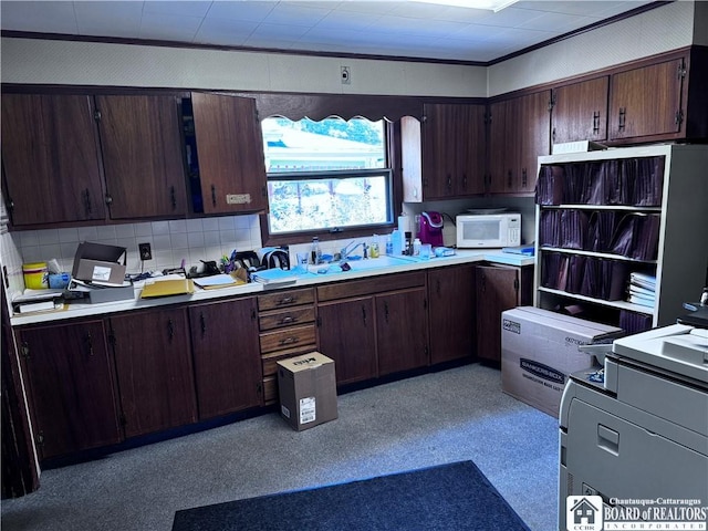 kitchen featuring decorative backsplash, sink, and dark brown cabinets