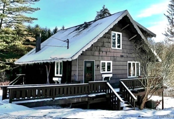 snow covered rear of property featuring a wooden deck