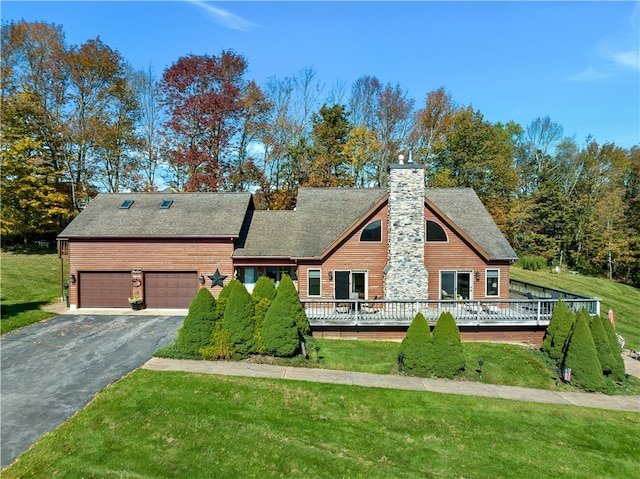 view of front of property featuring a garage, a deck, and a front yard