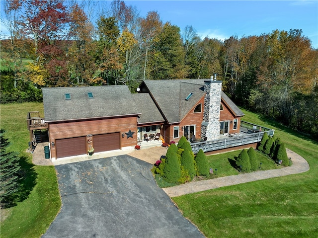 view of front of property with a wooden deck, a garage, and a front yard