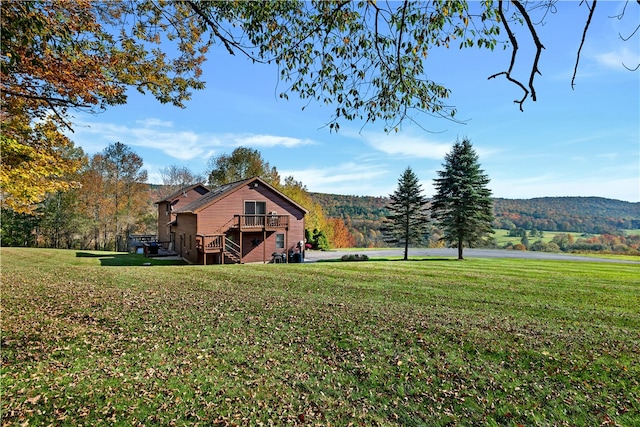 view of yard with a deck with mountain view and a rural view