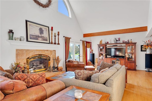 living room with a high end fireplace, high vaulted ceiling, and light hardwood / wood-style flooring