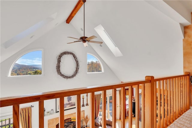 room details featuring ceiling fan, a skylight, and beamed ceiling