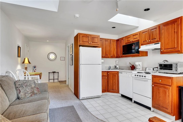 kitchen featuring light tile patterned floors, white appliances, and a skylight