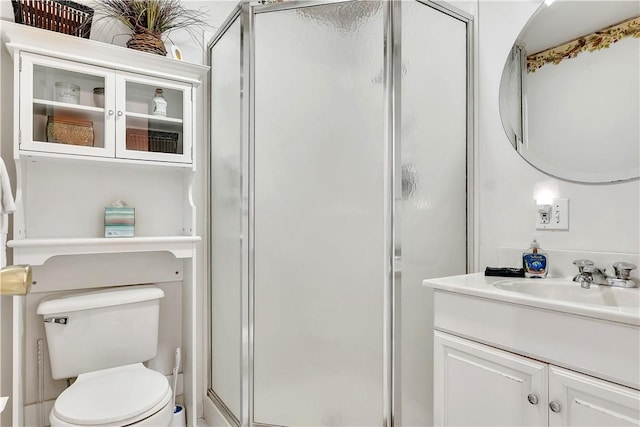 bathroom with vanity, a shower with shower door, and toilet