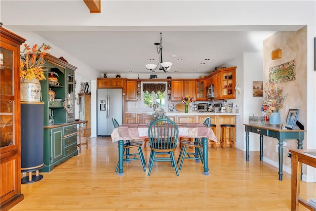 dining space featuring a notable chandelier and light wood-type flooring