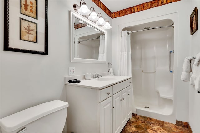 bathroom with walk in shower, vanity, and toilet