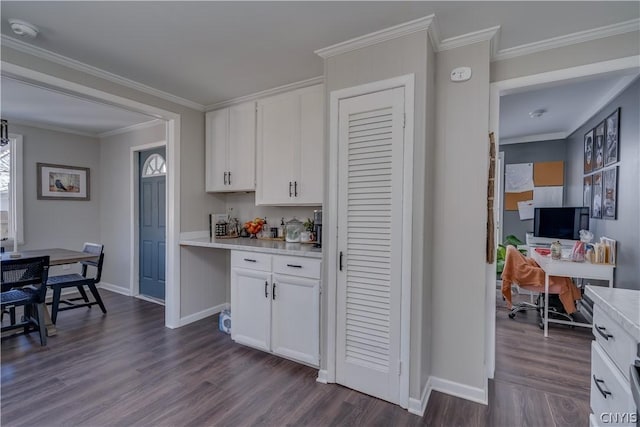 kitchen with white cabinetry, ornamental molding, and dark wood-type flooring