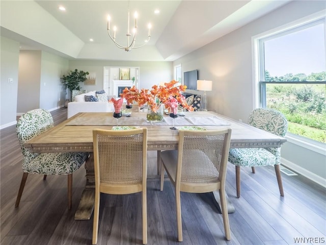 dining space featuring an inviting chandelier, dark hardwood / wood-style floors, and a raised ceiling