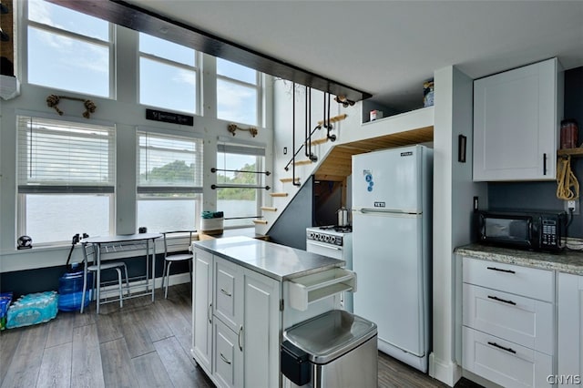 kitchen featuring white cabinetry, white fridge, and dark hardwood / wood-style flooring