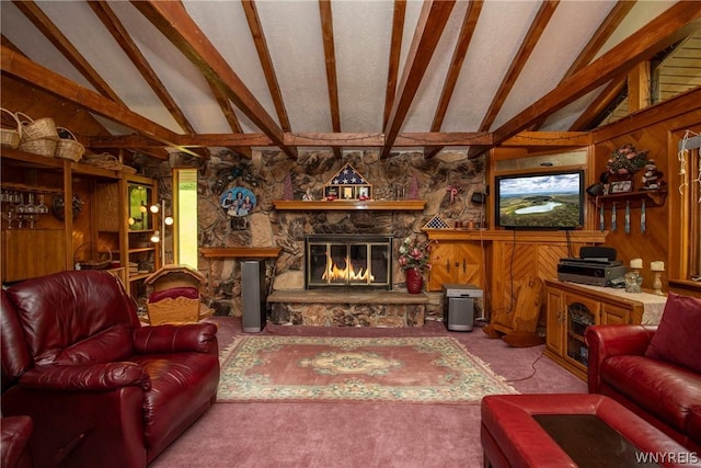 living area with lofted ceiling with beams, wood walls, carpet flooring, and a stone fireplace