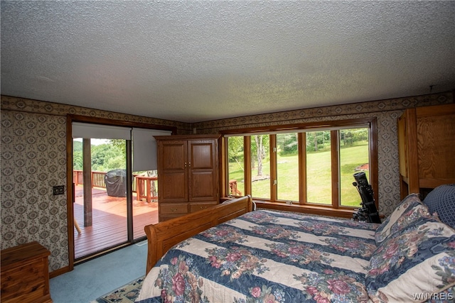 bedroom featuring multiple windows, carpet, and a textured ceiling