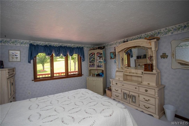 bedroom featuring a textured ceiling and wallpapered walls